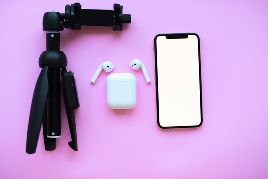 Mochup.Tripod ,air pods and telephone on pink background. High quality photo