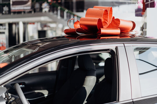 The New Car Is Wrapped In A Red Bow. Beautiful Gift Concept