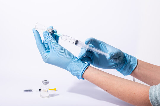 Doctor, researcher holds hands syringe in blue glove holding flu, measles, rubella or hv vaccine and syringe with needle vaccination for human.