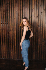 Fashion model in denim and black t-shirt in studio. Happy attractive female smile