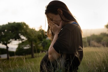 A stressed unhappy pregnant woman sitting alone covering her face. Prenatal depression.