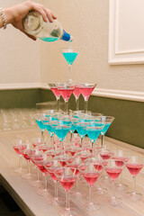 Pyramid of pink and blue cocktail glasses, party buffet, punch