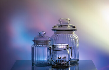 Glass empty jars on a colored background. Reflected light. Banks for storing bulk products. Still life. High quality photo