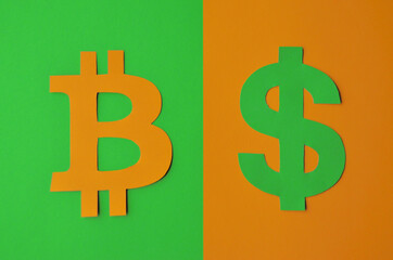 A bitcoin sign on a green background and a dollar sign on an orange background. Conceptual collage of paper about cryptocurrencies in the style of minimalism. High quality photo