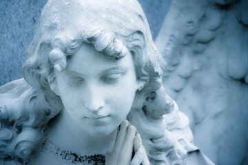 Guardian angel girl sculpture detail. Angel sad expression sculpture with eyes down and hands...
