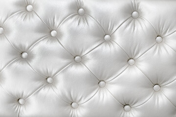 Texture of stylish soft white leather upholstery of sofa. White material is decorated with leather buttons.