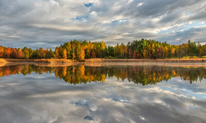 Beautiful morning light with autumn color reflection on the lake at the Backus Township Park in...