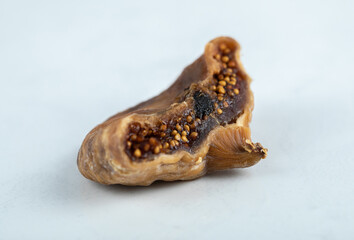 Single dried fig on white background