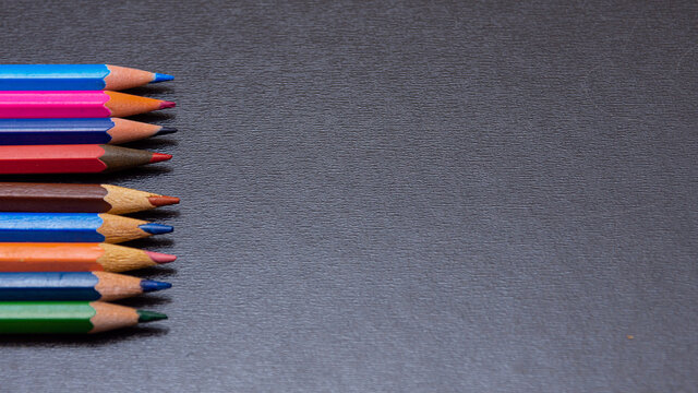  Row of colorful wooden pencils on blackboard background with copy space, back to school concept