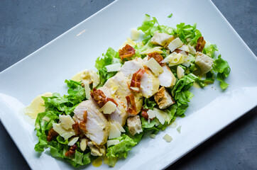 Healthy diet with colorful and tasty Caesar Salad with lettuce, grilled chicken, parmesan cheese and grilled bacon