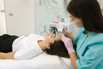 Female at cosmetic beauty spa clinic has facial hardware cosmetology. Woman making beauty procedures