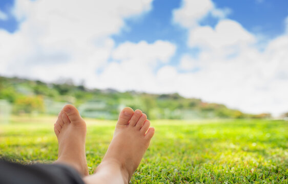 child's bare feet relaxing in grass field on a sunny day