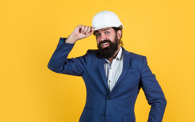 brutal bearded man work on construction site. working on project. building concept. builder or engineer in hard hat. welcome on board. happy mature architect in helmet