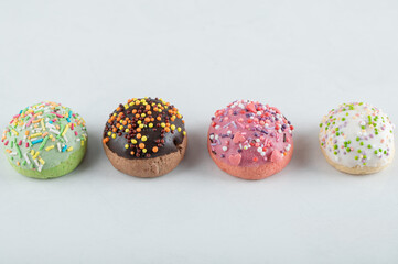 Colorful cookies decorated with sprinkles on white background