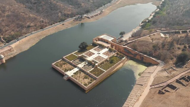 Kesar Kyari Bagh garden on Maota Lake, right before Amber Fort, in Jaipur, Rajasthan, India - Aerial Wide Orbit shot