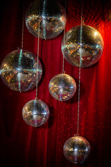 design of a photo zone for guests - mirror disco balls against the background of a red velvet...