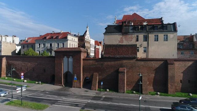 The walls of the old town in Toruń and historic tenement houses with red roofs. Beautiful sunny and summer day with a blue sky.