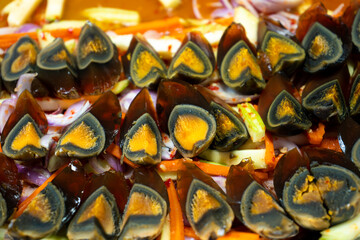 Street food market in Asia. A close-up, traditional dish of sliced pickled chicken eggs