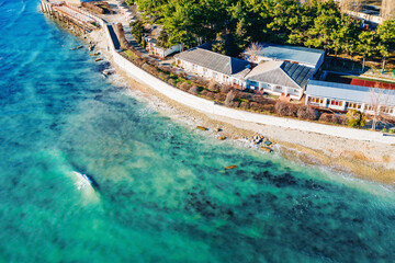 Aerial view at sea coastline with buildings near ocean water, beautiful azure water, summer travel concept.