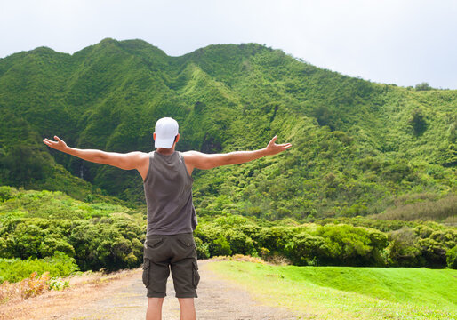 Young Adventurous Man With Arms Up Feeling Alive And Energized In A Nature Mountain Setting 