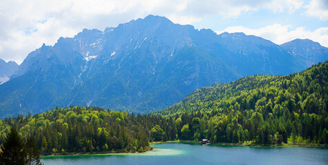 Fototapeta na wymiar alpine landscape at springtime, lake Lautersee and green forest, bavarian mountains
