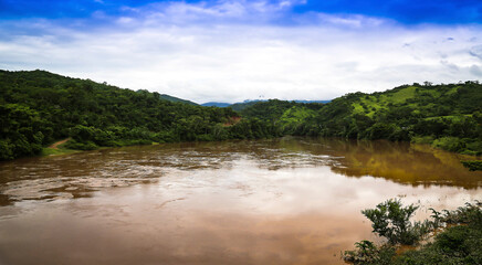 Fototapeta na wymiar Huallaga river of the Peruvian high jungle. River among vegetation with light blue sky and white clouds.