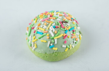 Fototapeta na wymiar Green cookie with sprinkles on white background