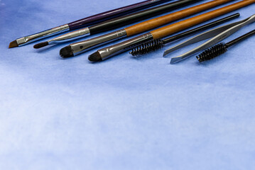 Soft focus on brushes. Close up on set of brushes for make up on purple background.  Concept for make up instruments. Tools for woman beauty.