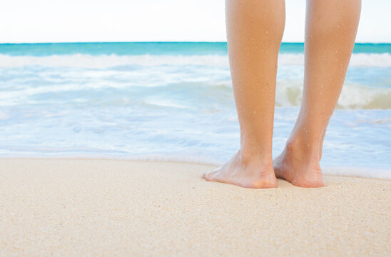 Woman standing on a white sand beach. Travel holiday concept. 