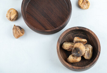 Bowl of dried figs around wooden plate