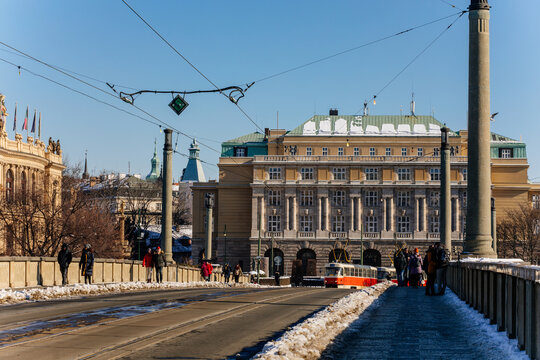 Neoclassical building Faculty of Liberal Arts, Charles University at Jan Palach Square, Manes Bridge over the vltava river, snow, sunny winter day, Old Town, Prague, Czech Republic