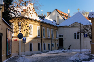 Former ossuary and chapel of the Holy Trinity at Hastal Square near Medieval Convent of Saint Agnes, narrow street under snow in sunny winter day, Old Town, Prague, Czech Republic