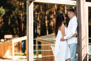 Portrait of cheerful woman and man spending time together outdoors, kissing, hugging and laughing on summer terrace, couple in love on valentine's day togetherness