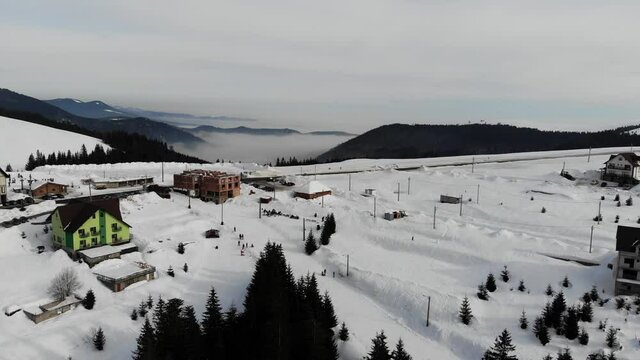Flying over a slope in the Parang Mountains at Ranca covered with snow on a sunny day