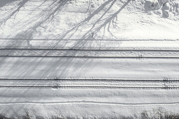 Aerial view of a double-track railway after heavy snowfall. Winter rail road with white snow, top view