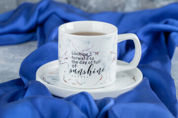 Cup of hot tea on blue cloth