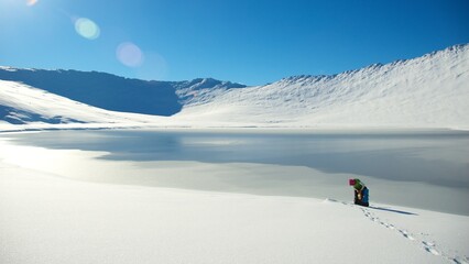 Persona sacando agua lago congelado Dientes de Navarino Puerto Williams Patagonia Austral Cabo de Hornos Region de Magallanes Chile