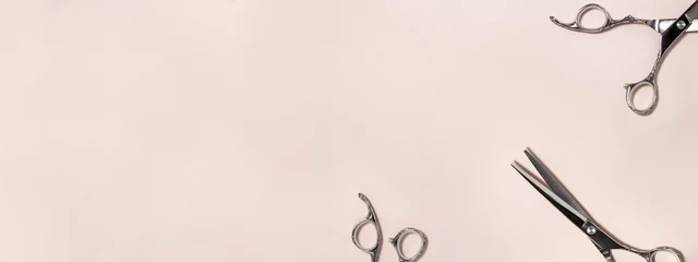 Selbstklebende Fototapeten Friseursalon Banner flat lay from above of professional silver hair cutting shears set on pink background. Hairdresser salon equipment and haircut work tools concept during quarantine with copy space  © Four season lover