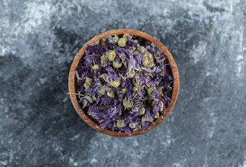 Fototapeta na wymiar Dried purple flowers in wooden bowl
