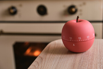 modern kitchen timer apple shaped on the background of the kitchen - obrazy, fototapety, plakaty