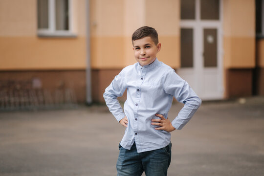 Happy Schoolboy In Front Of School. Cute Boy Finish School Year