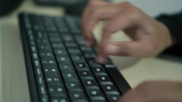 Hands of worker using typing on keyboard, close up side view