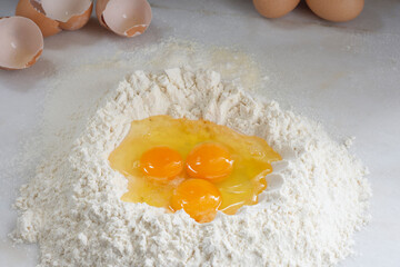 Raw chicken egg and flour on white background, homemade pasta.