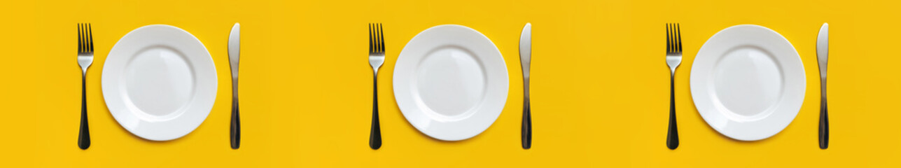 Three sets of white empty plates, stainless forks and knives lie on a yellow tablecloth. Minimalist table setting concept, top view. Intermittent fasting, diet. Copy space, layout.