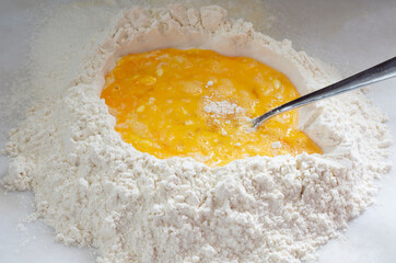 chicken eggs and homemade pasta whipped flour on a white background.
