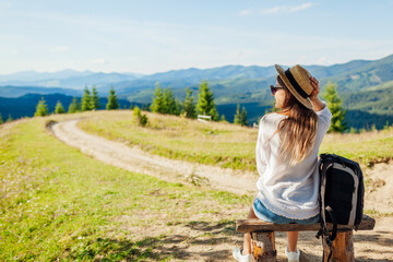 Trip to Carpathian mountains. Woman tourist hiking and relaxing admiring landscape. Traveling...