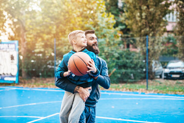 Obraz premium Father and his son enjoying together on basketball court.