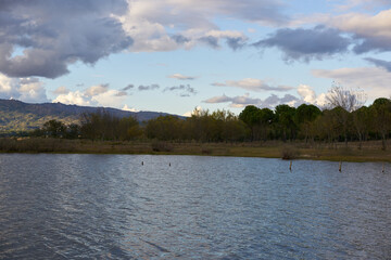 Lake dam landscape with reflection of Gardunha mountains and trees on a cloudy day in Santa Agueda Marateca Dam in Portugal