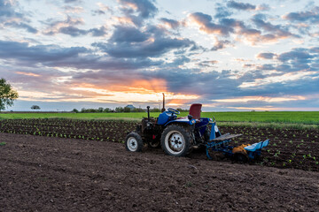 Obraz premium tractor in the middle of a field at sunset rural landscape close-up