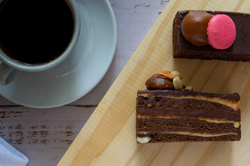2 porciones de torta de chocolates vistas desde arriba con una taza de café